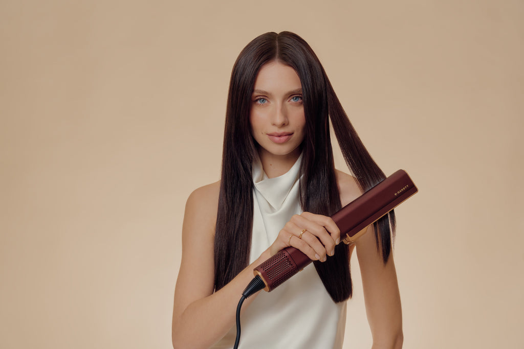 Femme lissant ses cheveux bruns avec le lisseur à air Beauty AeroGlow