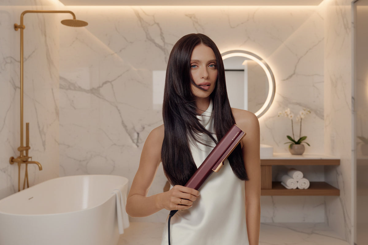 Femme aux cheveux longs et lisses tenant le lisseur à air Beauty AeroGlow